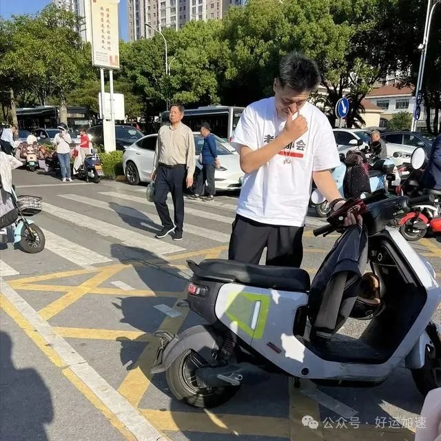 张雪峰苏州校门口接娃：电动车旁发呆，周围竟无人搭理，引发热议